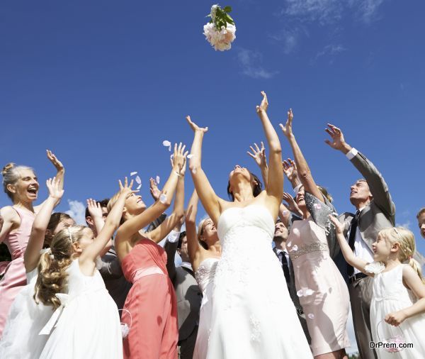 Bride Throwing Bouquet For Guests To Catch
