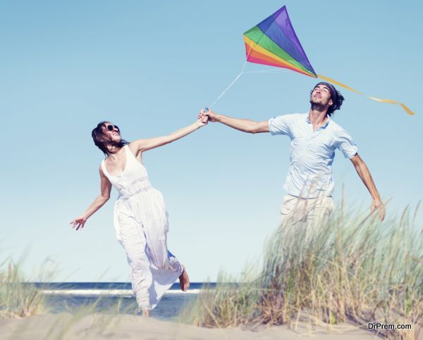 Cheerful Couple Playing Kite by the Beach