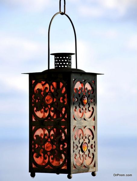 Outdoor citronella lantern suspended over table and chairs.