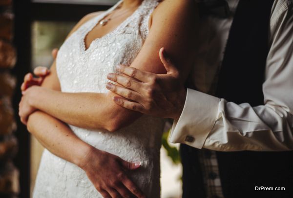 groom gently embraces the bride