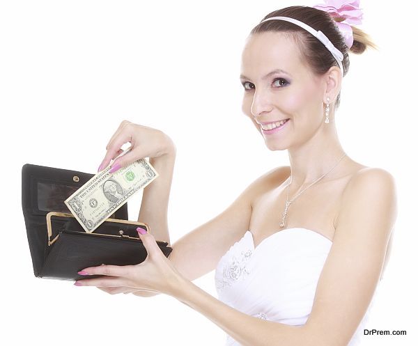 Marriage and money concept of high wedding cost. Bride with purse with one dollar isolated