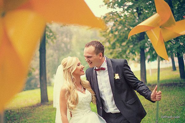 Newlyweds are in a park with toy wind turbine