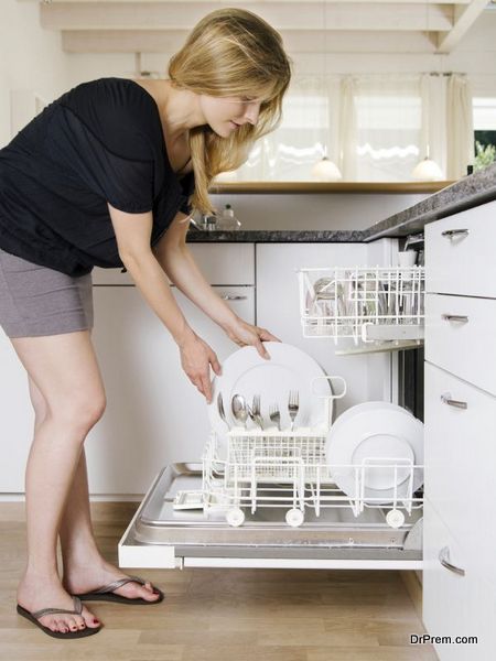 Photo of a blond female leaning over and unloading her dishwasher.