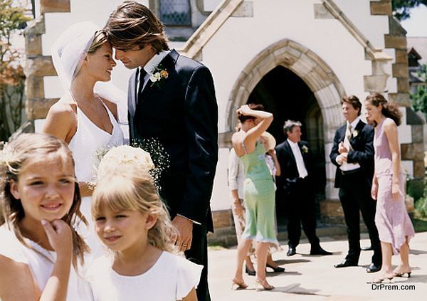 Bride and Groom Kissing By the Entrance of a Church