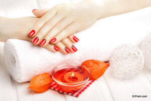 beautiful red manicure with dekor and towel on the white wooden table. spa